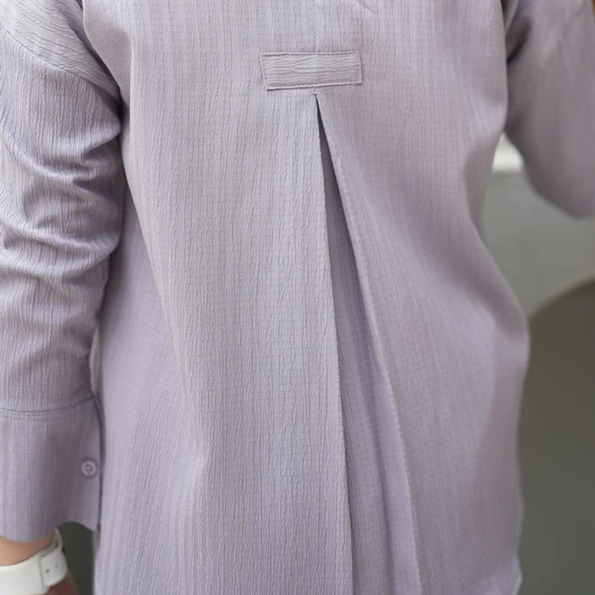 Close-up of the grey co-ord shirt showing the front pleat and textured fabric