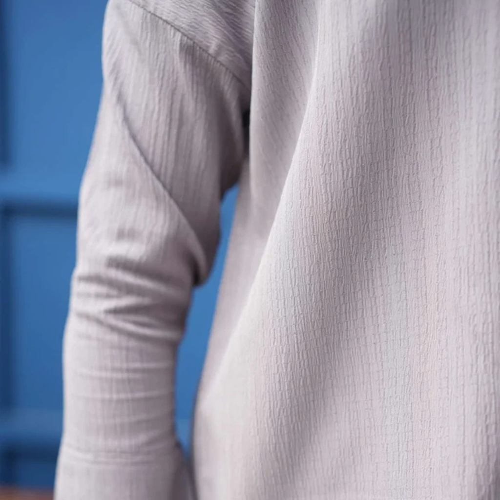 Close-up of the grey co-ord shirt sleeve and textured fabric