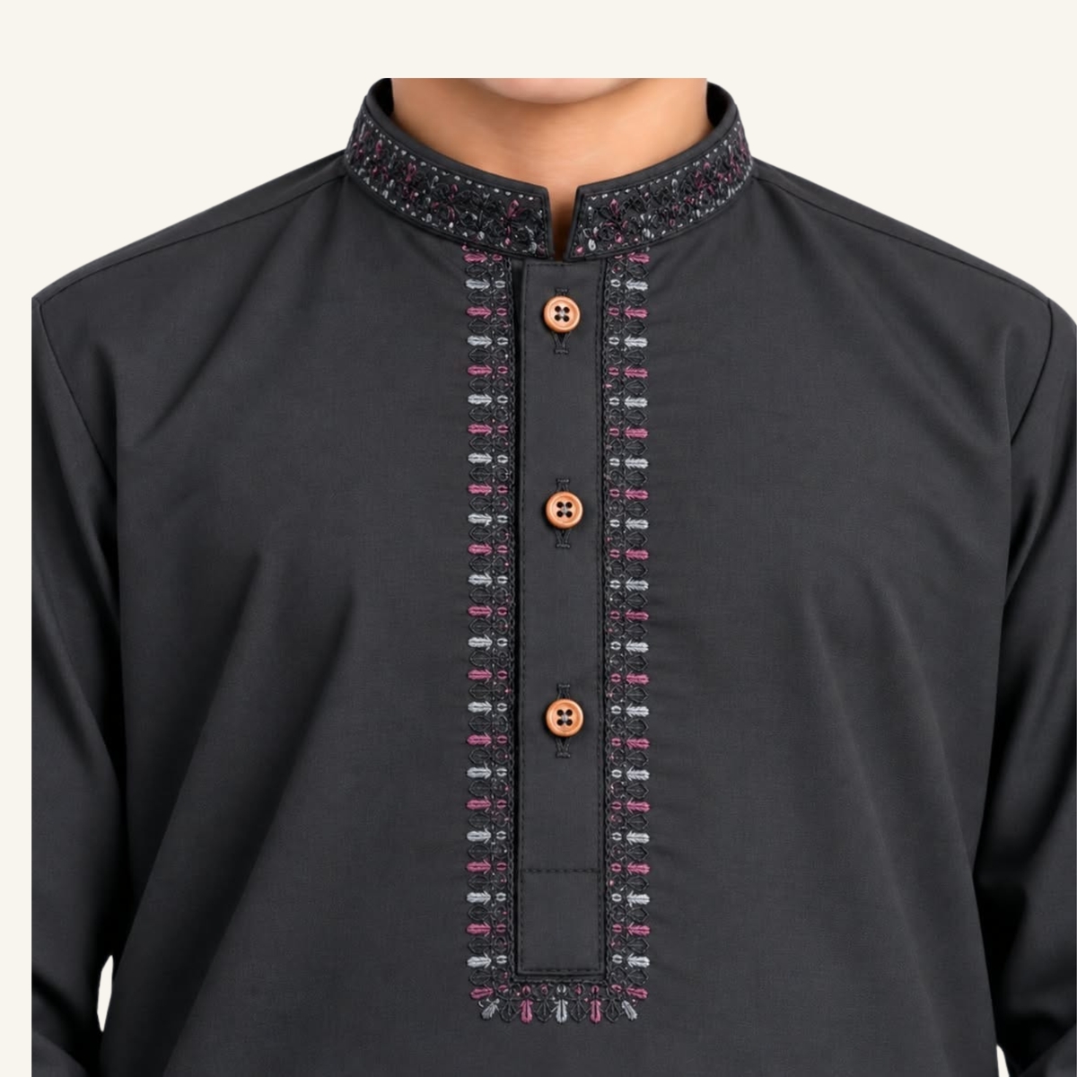 Close-up of red embroidery and buttons on the black boys’ kurta collar and placket