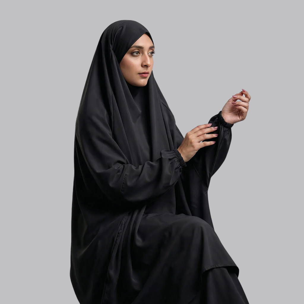 Close-up of a woman wearing the black jilbab with draped head covering and gathered cuffs