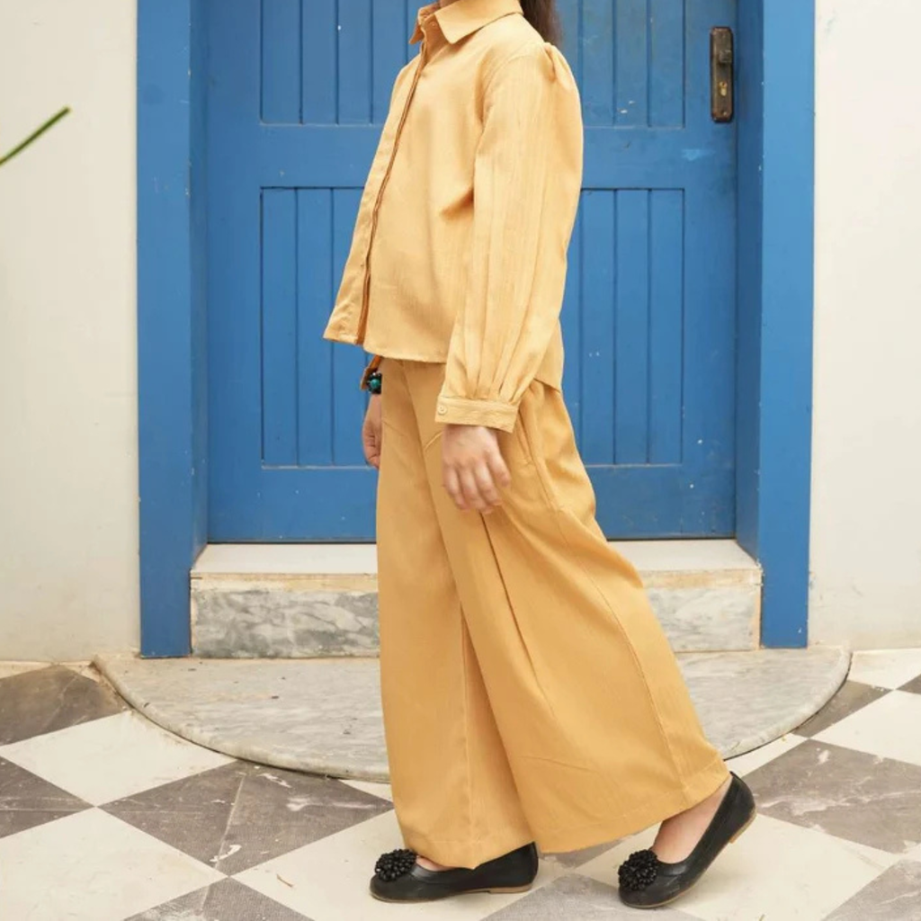 Side view of the sandy yellow teen girls’ shirt with matching wide-leg trousers