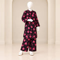 Girls’ black and pink two-piece suit with pink blossom-and-stem motifs over a black base, a long-sleeved top and matching trousers