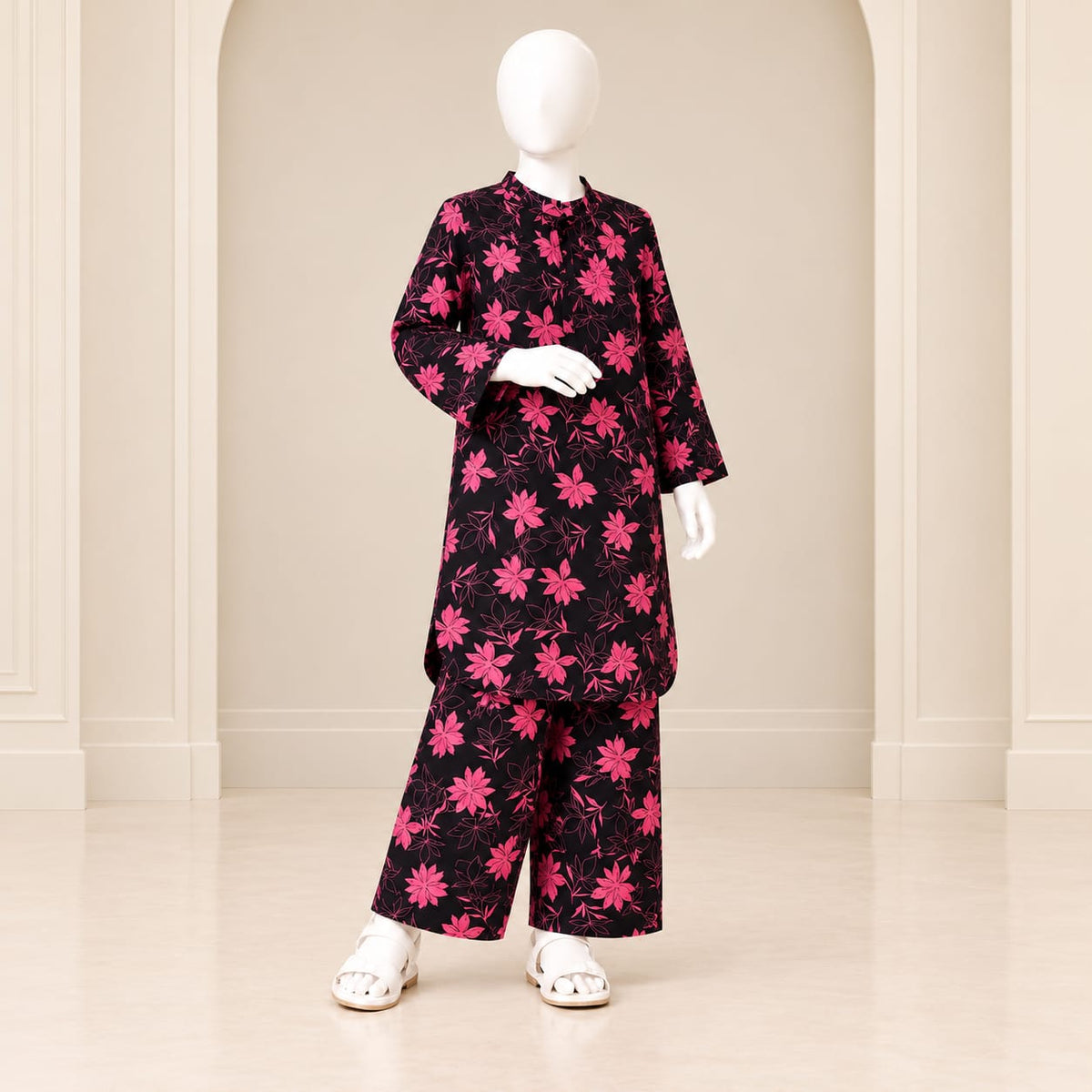 Girls’ black and pink two-piece suit with pink blossom-and-stem motifs over a black base, a long-sleeved top and matching trousers