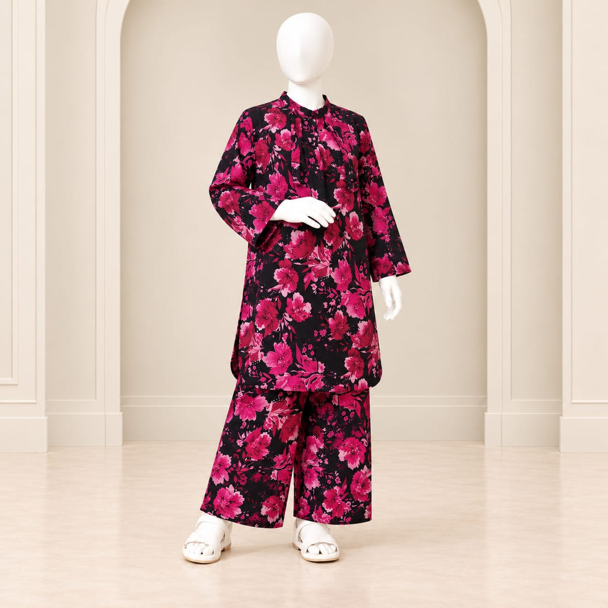 Girls’ black and pink two-piece suit with a dense rose print in pink shades against black, a long-sleeved top and matching trousers