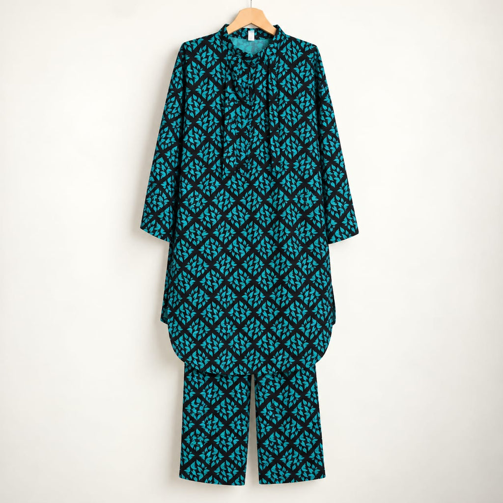 Black and teal girls’ printed shirt and matching trousers displayed on a hanger