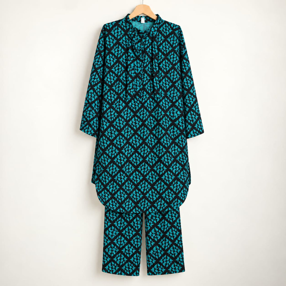 Black and teal girls’ printed shirt and matching trousers displayed on a hanger