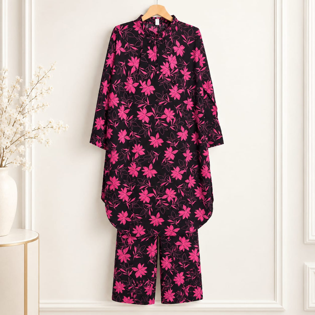 Black girls’ shirt with pink blossom print and matching trousers on a hanger