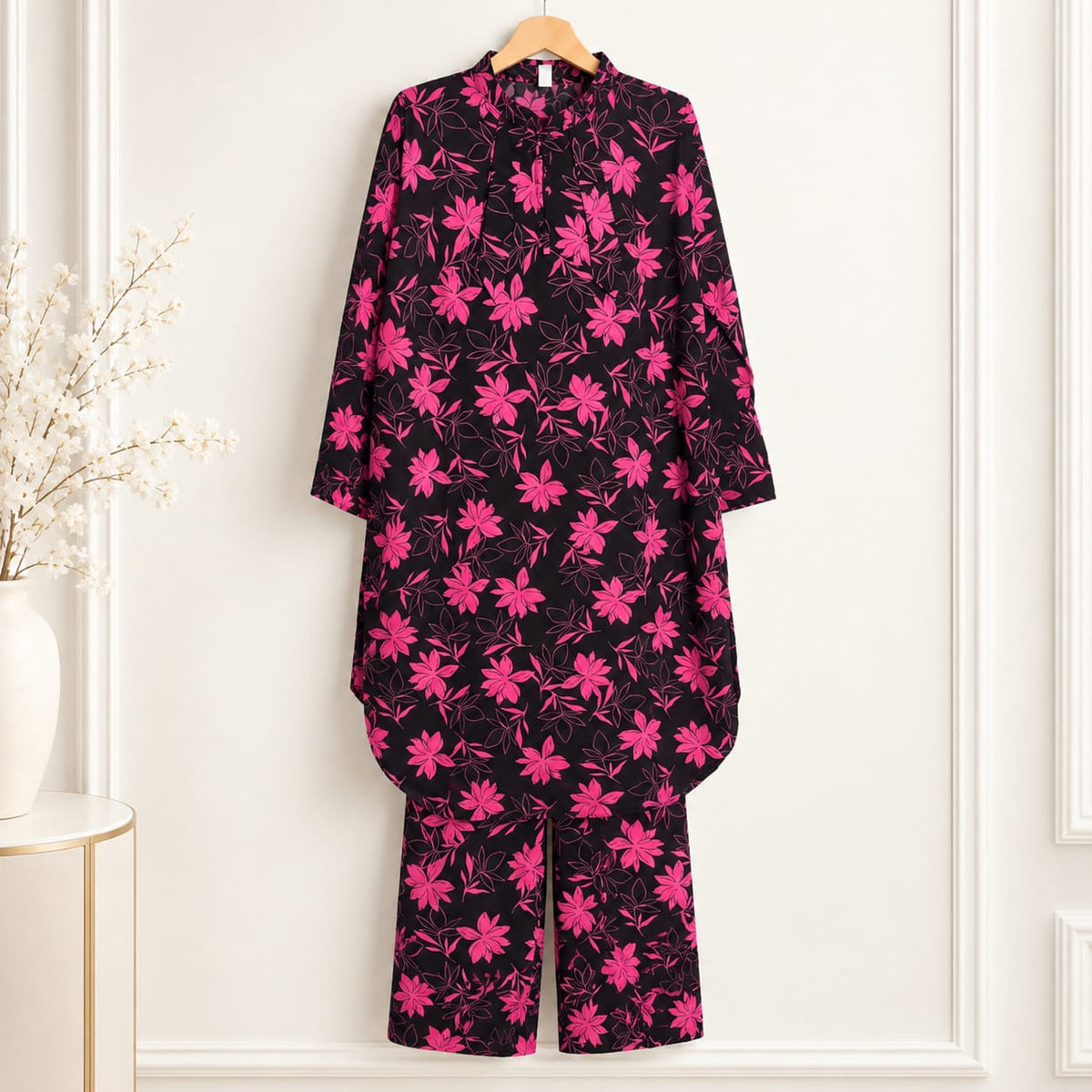 Black girls’ shirt with pink blossom print and matching trousers on a hanger