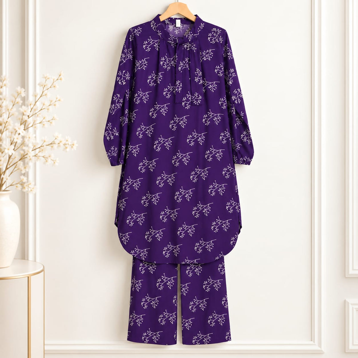 Purple girls’ long-sleeved floral shirt and matching trousers on a hanger