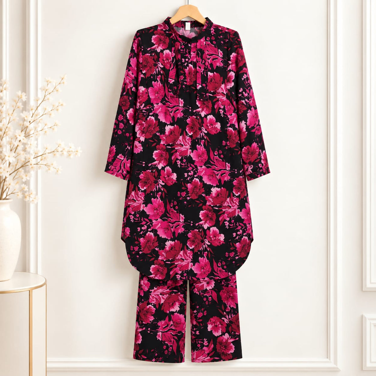 Black girls’ outfit with pink rose print and matching trousers displayed on a hanger